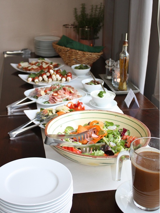 A buffet table with bowls of salad and cold appetizers